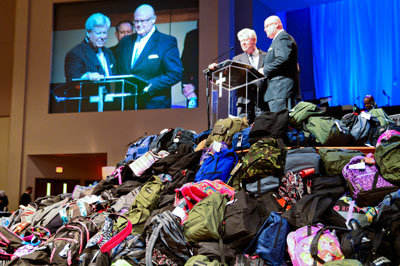 J. Robert White, executive director of the then-Georgia Baptist Convention (now Georgia Baptist Mission Board), left, and First Statesboro Pastor John Waters, right, announce that 22,500 backpacks were collected at the 2014 annual meeting at First Baptist Church of Woodstock. In 2012, the first year of the campaign, 4,400 were collected. The collection was the vision of Waters when he served as Convention president. KELLY DURHAM/Index