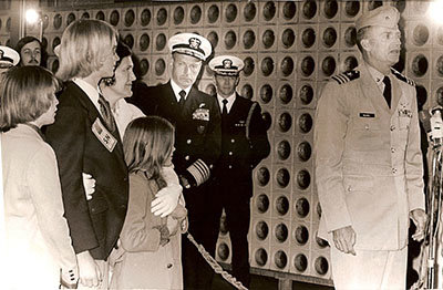 Following six years as a POW in North Vietnam, Navy Captain Eugene "Red" McDaniel (right) addresses the media after arriving at Portsmouth Naval Hospital. His wife Dorothy and their children Michael, David, and Leslie stand nearby. Photo courtesy of Red McDaniel