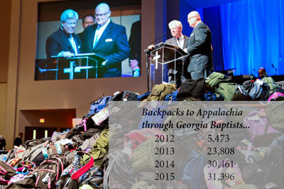 J. Robert White, executive director of the then-Georgia Baptist Convention (now Georgia Baptist Mission Board), left, and First Statesboro Pastor John Waters, right, announce that 22,500 backpacks were collected at the 2014 annual meeting at First Baptist Church of Woodstock. The collection was the vision of Waters when he served as Convention president. KELLY DURHAM/Index