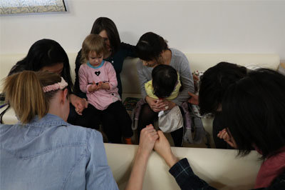 People gather to pray during a Sunday service at a church plant that meets in a pediatrician’s office in Japan. IMB missionaries Jared and Tara Jones – beneficiaries of the Lottie Moon Christmas Offering – partnered with their pediatrician to help start the church, which they pray will be a lighthouse to the community for generations to come.