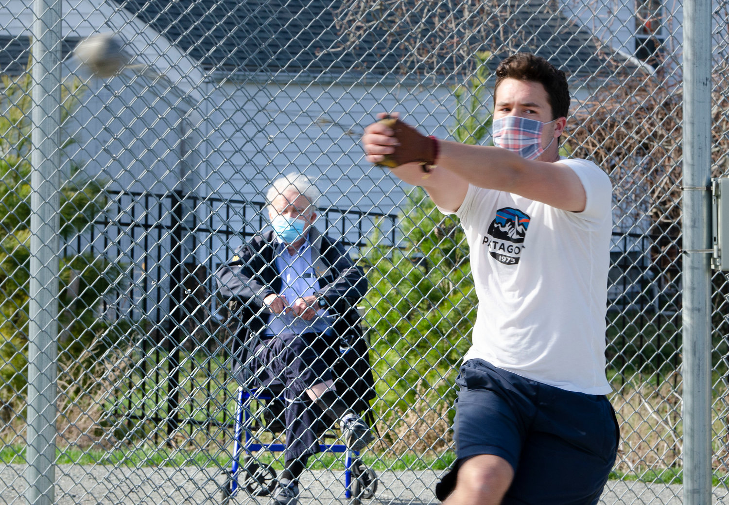 Longtime Barrington High School throwing coach Bob Gourley watches the Eagles’ Liam Capozza throw the hammer during a recent practice session.