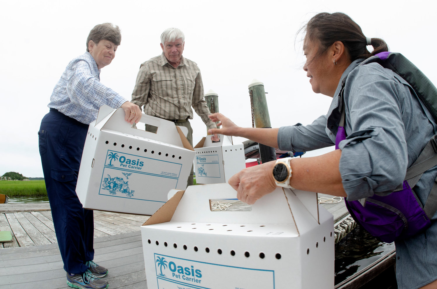 Harold and Judy Isaksen exchange empty boxes for some with fledglings with Tih-Fen Ting.