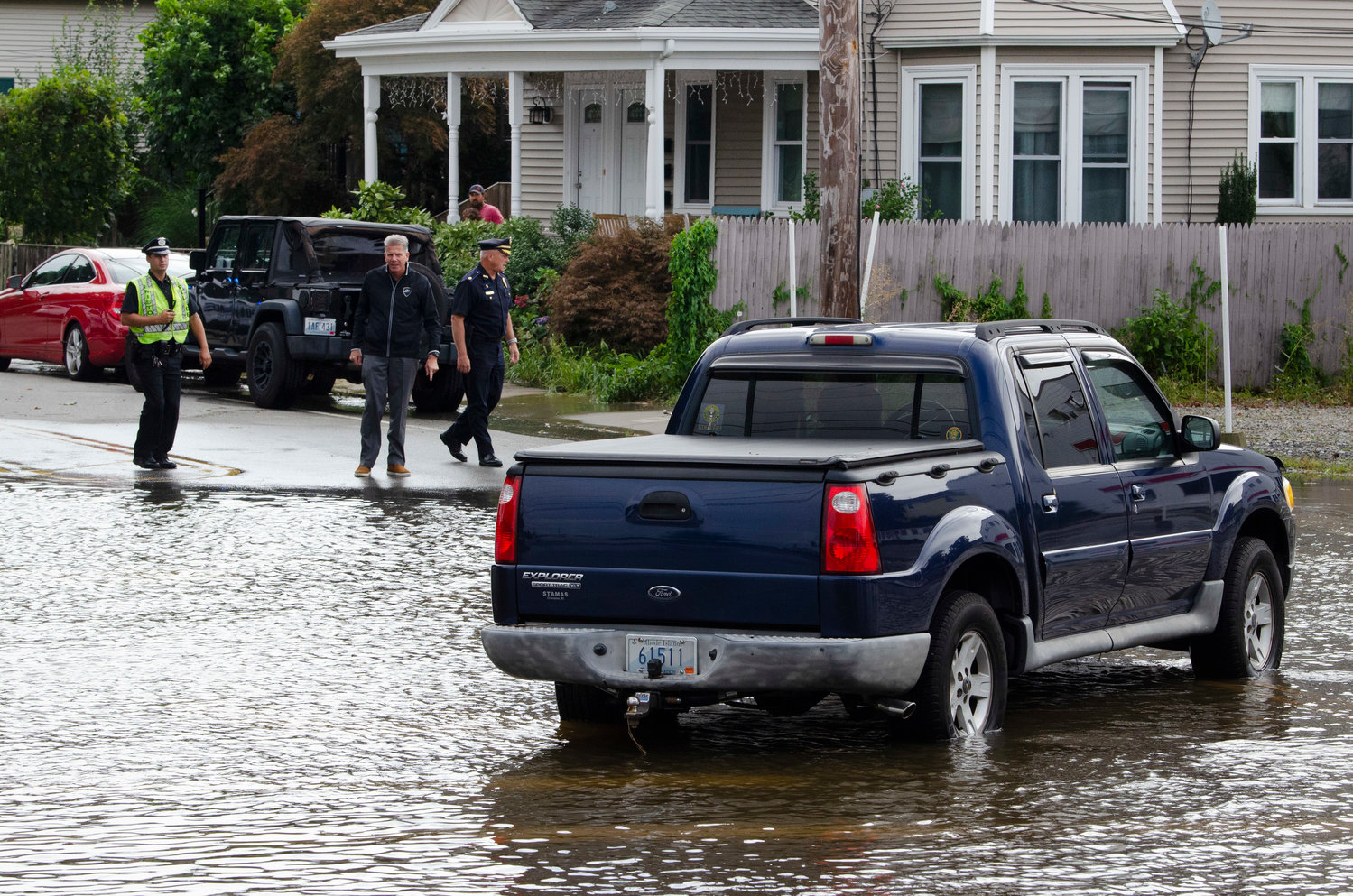 Bristol Police Chief Kevin Lynch (left), a patrolman and Major Scott McNally (right) check out flooded Washington and Hope Streets on Thursday morning.