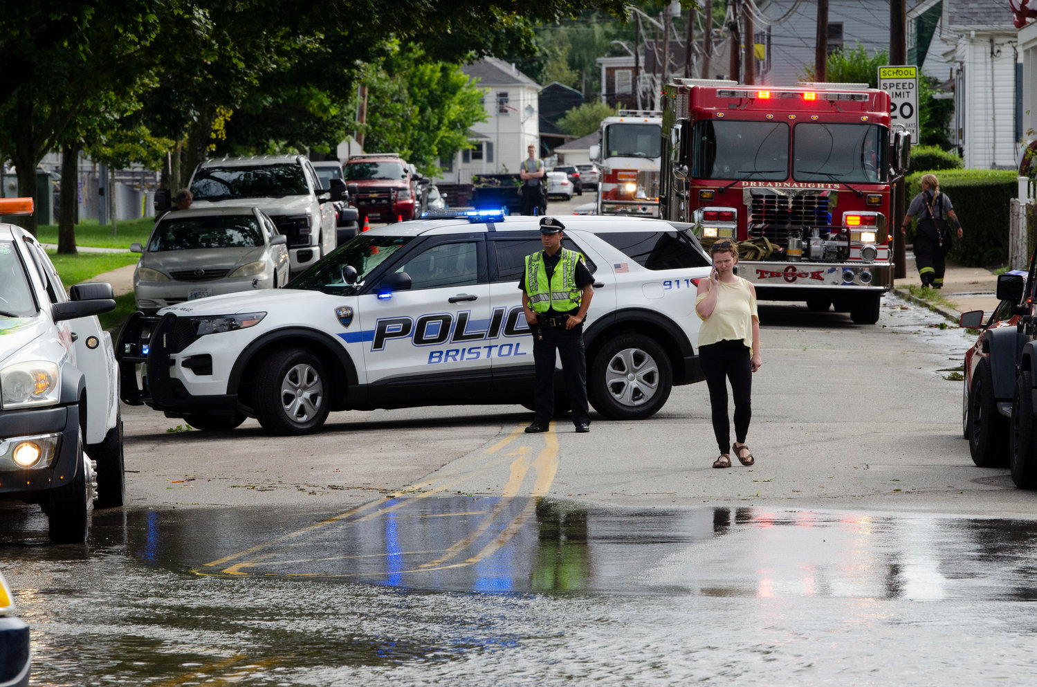 A Bristol Policeman looks on as a woman waits for a tow truck after getting stuck in the flood on Washington Street.