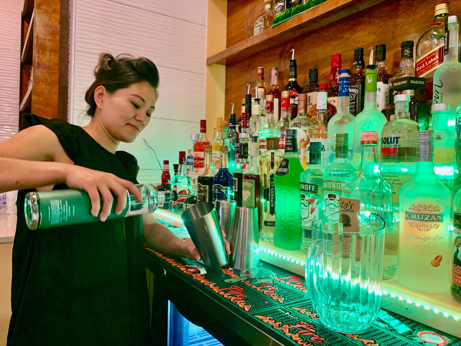 Mindy Zhang, owner of Mindy’s Restaurant and Sushi Bar in Portsmouth, pours a drink at the bar on Tuesday. The establishment, which recently opened, is the former site of Reidy’s Family Restaurant.
