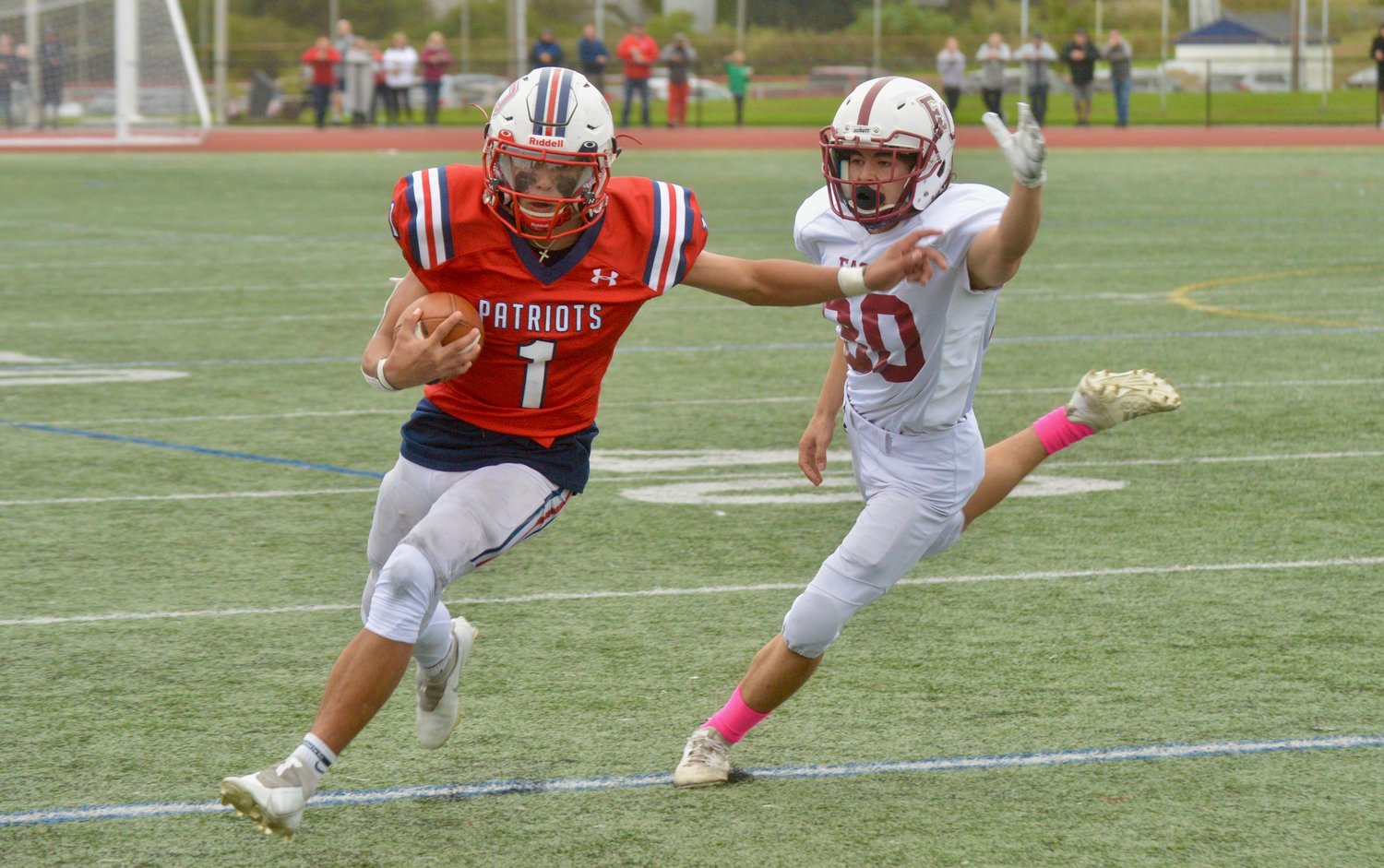 The Patriots’ Carson Conheeny rushes for a big gain in the second half as he’s hotly pursued by an East Greenwich defender.