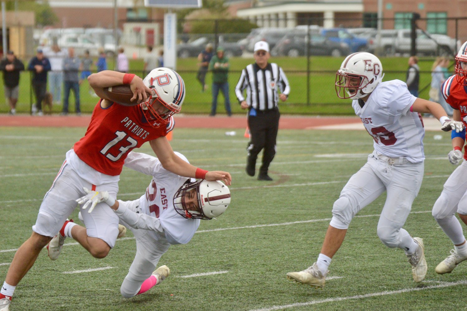 The Patriots’ Evan Beese works hard for a rushing gain as he tries to avoid a tackle.