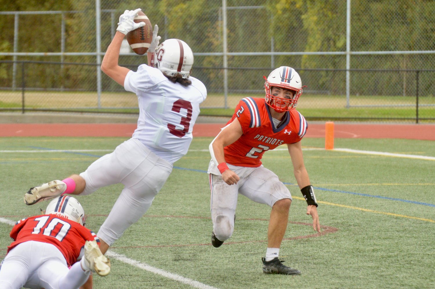 The Avengers’ Evan Macaulay scores the first touchdown of the game despite receiving a hard hit from Ben Hurd (right).