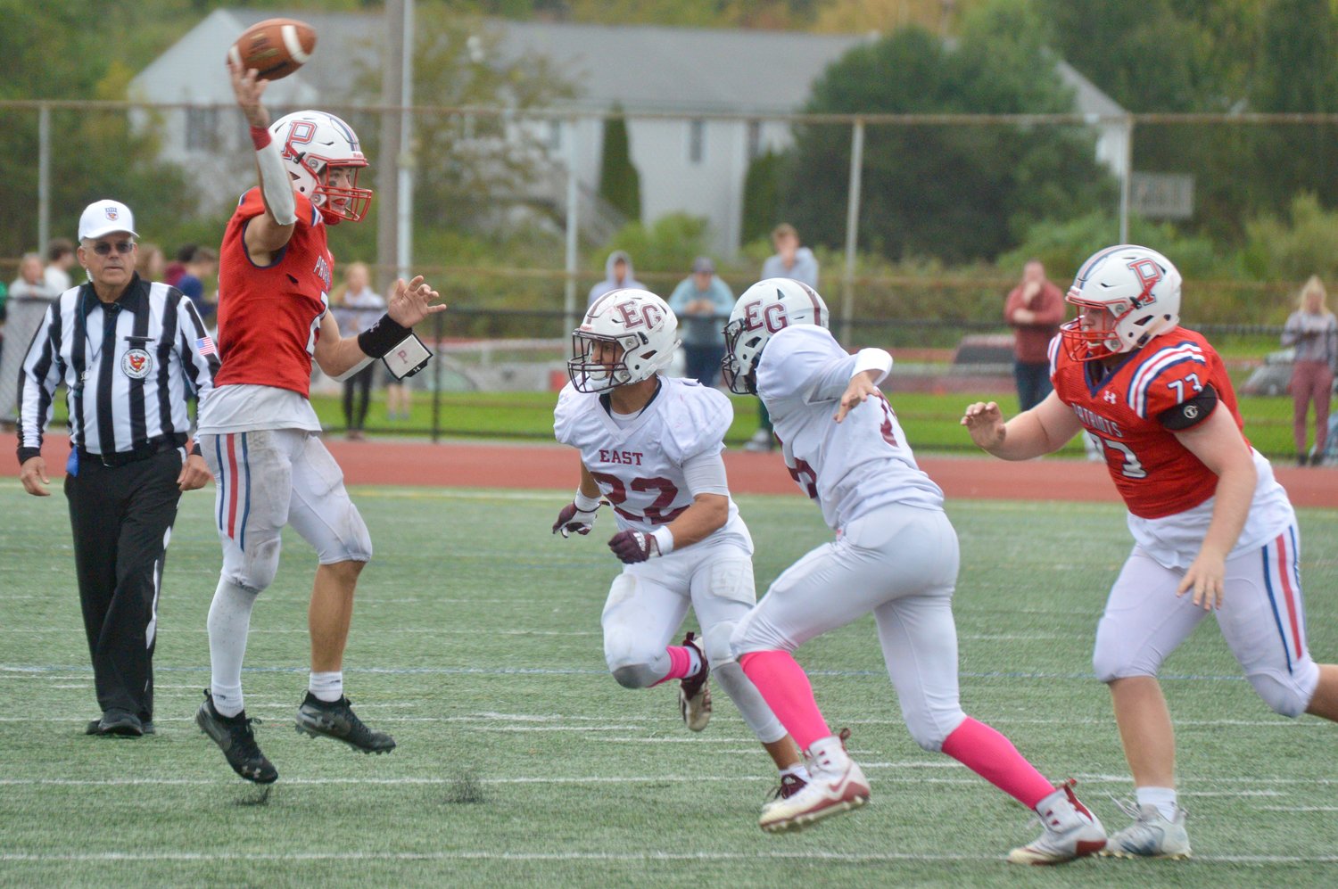 Portsmouth High quarterback Ben Hurd passes over two defenders in the first half of Saturday’s Homecoming game against East Greenwich. He had a big day, to say the least.
