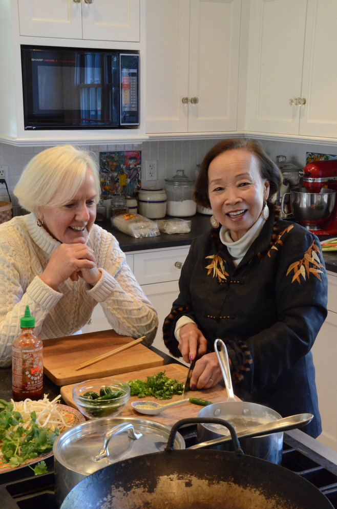 Julia Califano (left) watches Mai Donogue create a delicious meal. The two longtime Barrington residents recently published a cookbook of Vietnamese recipes they began compiling more than 25 years ago.