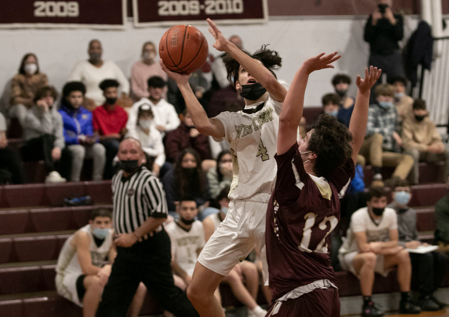 Westport guard Ben Boudria leaps over Owen Pasquale to make a jumper.