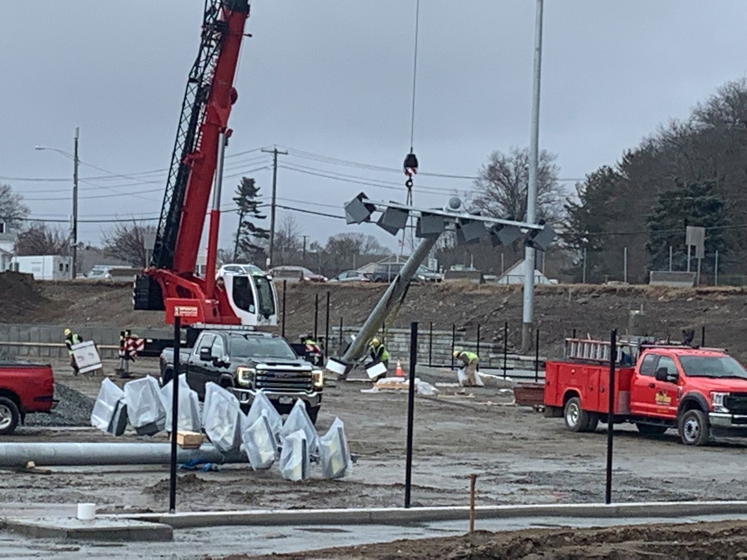 Crews raise light posts at the sight of the baseball field on the new EPHS grounds Wednesday morning, Jan. 5.