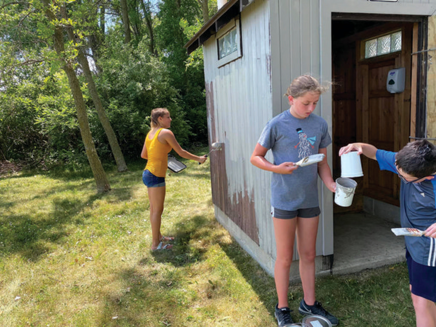 PAINTING THE OUTHOUSE (pictured, from the left) Hannah Sanders, Sloan Rodemeyer and Cael Rodemeyer at Duhigg Park.
