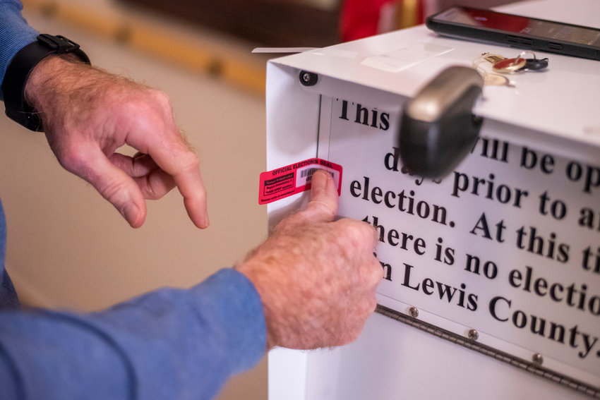 Lewis County Auditor Larry Grove checks a ballot box in February 2020.