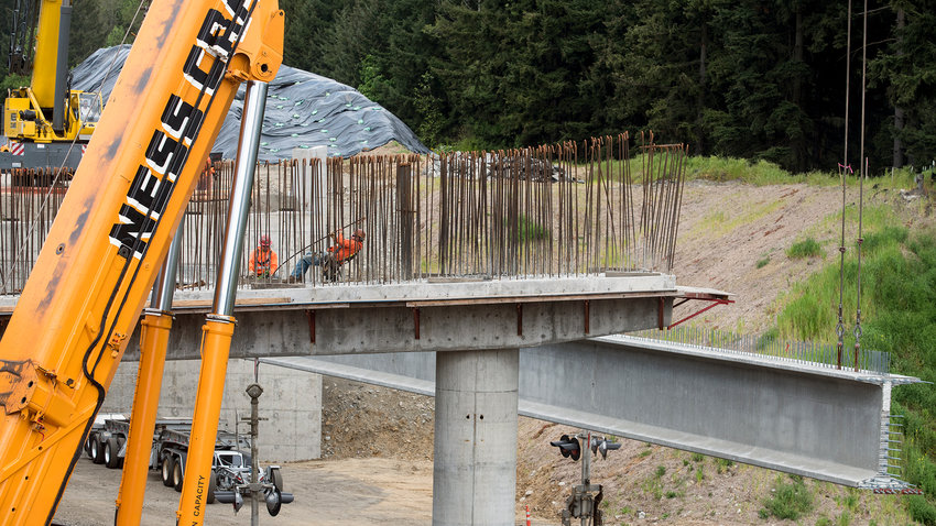 2015 FILE PHOTO &mdash; A construction worker pulls on rebar as the third of six 160-foot girders is lifted into place for the Blakeslee Junction bridge on Interstate 5 in May 2015.