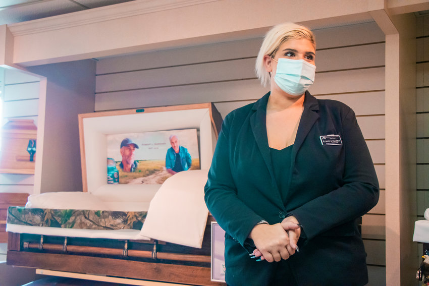 Rebecca Harris, licensed funeral director and embalmer, talks about her job in front of display caskets at the Newell-Hoerling&rsquo;s Mortuary on Wednesday in Centralia.