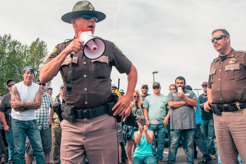Sheriff Rob Snaza speaks with a megaphone to Hamilton sign supporters in the parking lot of Bethel Church in Napavine in June 2020.
