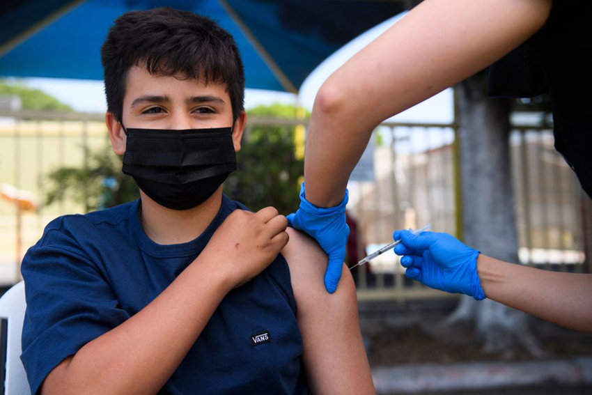 Simon Huizar, 13, receives a first dose of the Pfizer Covid-19 vaccine at a mobile vaccination clinic at the Weingart East Los Angeles YMCA on May 14, 2021 in Los Angeles, California. (Patrick T. Fallon/AFP via Getty Images/TNS)