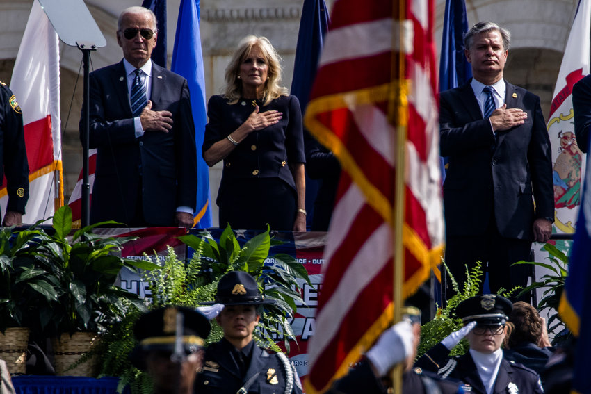 From left, President Joe Biden, first lady Jill Biden, and FBI Director Christopher Wray stand for the national anthem at the 40th Annual National Peace Officers Memorial Service on the West Front of the U.S. Capitol Building on Saturday, Oct. 16, 2021, in Washington, D.C. (Samuel Corum/Getty Images/TNS)