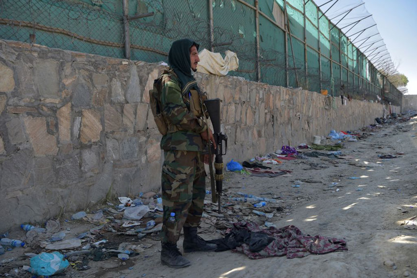 A Taliban fighter stands guard at the site of the Aug. 26 twin suicide bombs, which killed scores of people including 13 U.S. troops, at Kabul airport on August 27, 2021. Since then, State Department continues to be in touch with hundreds of Americans who want to leave Afghanistan.  (Wakil Kohsar/AFP via Getty Images/TNS)