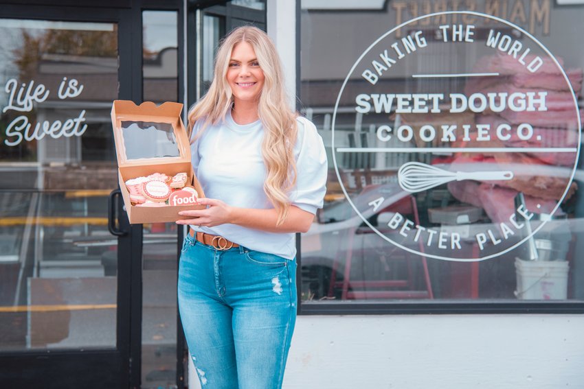 Ashlee Shirer, owner of Sweet Dough Cookie Co. smiles while holding a box of cookies outside her Centralia storefront Tuesday afternoon.