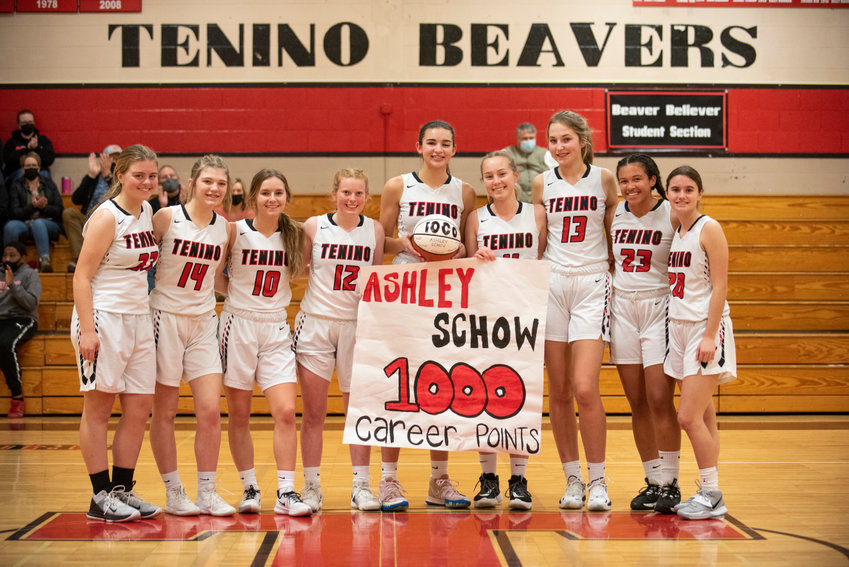 Tenino senior Ashley Schow, holding the ball, poses with her teammates after scoring her 1,000th point during a home game against Cascade Christian on Dec. 20, 2021.